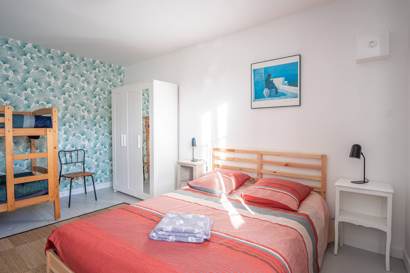 Une chambre avec un lit et des lits superposés.