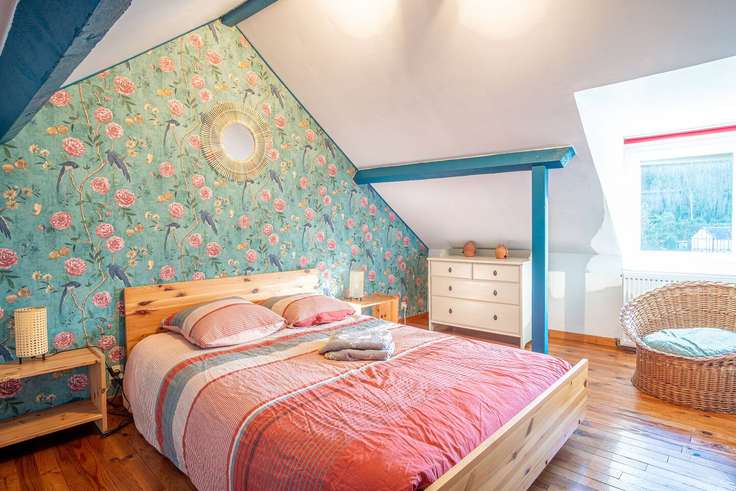 Une chambre avec un lit, une commode, une table de chevet et une chaise.