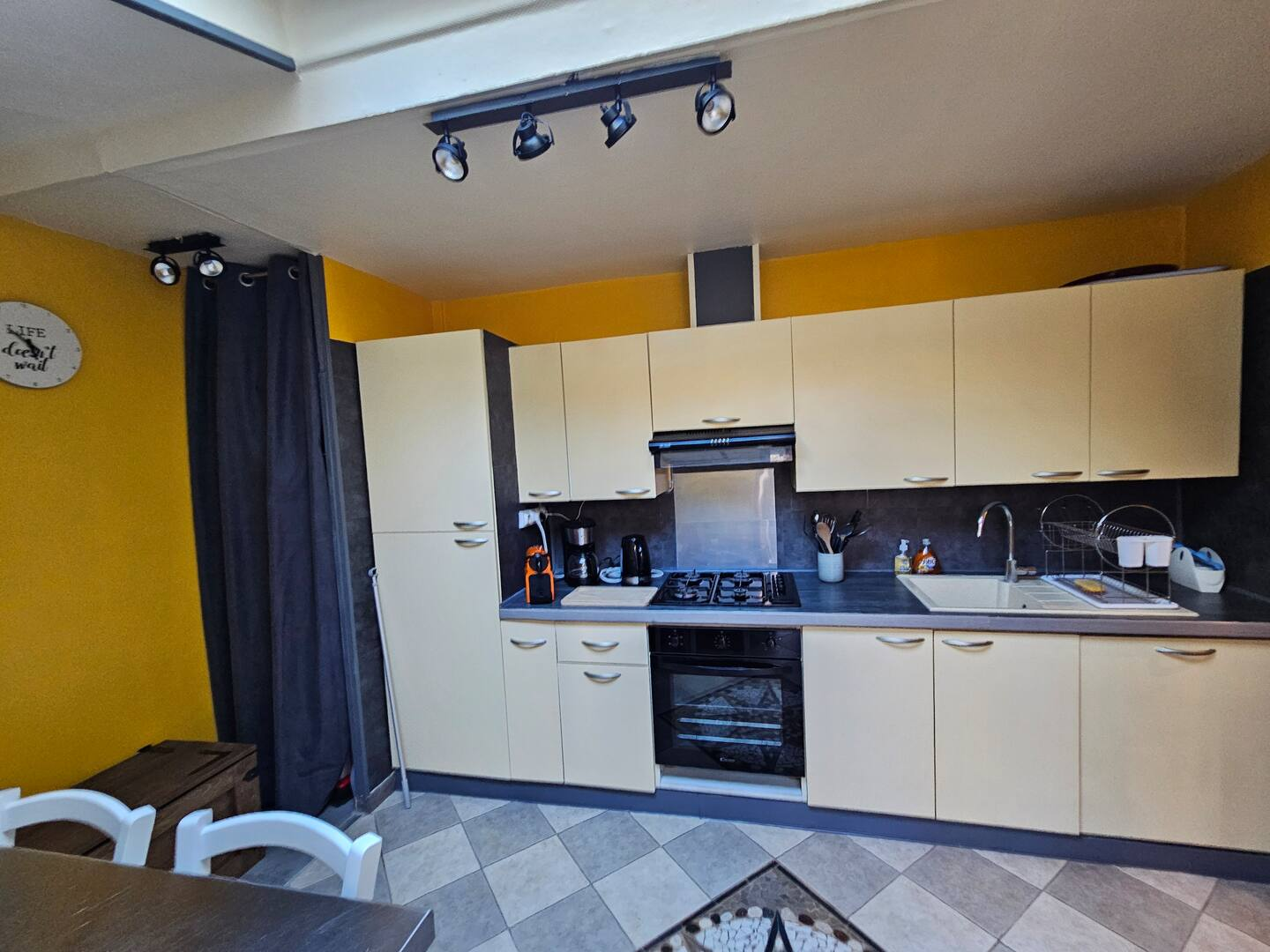 Une cuisine avec des armoires blanches et un four à plaques de cuisson