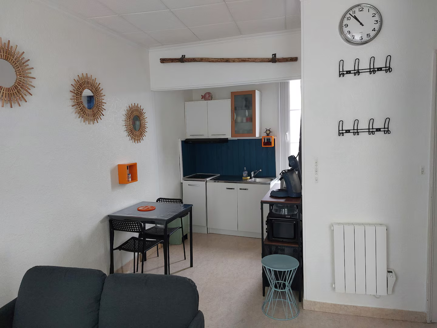 Un salon avec un canapé, une table et une horloge au mur