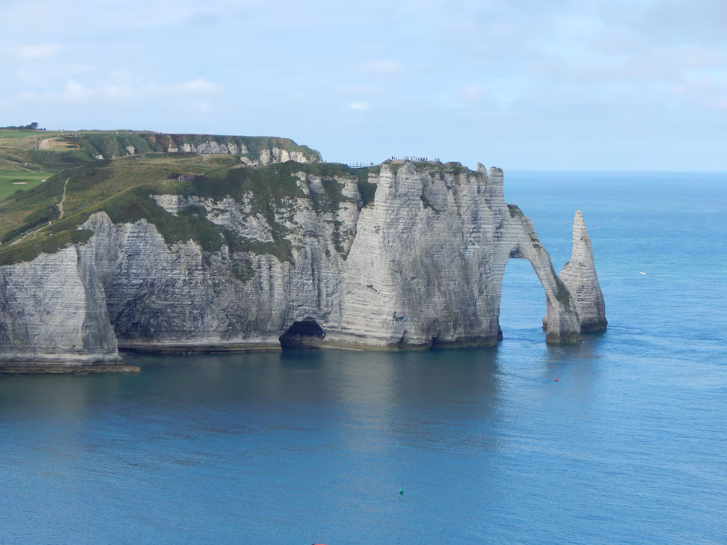 Une grande formation rocheuse au milieu de l'océan entourée d'eau.