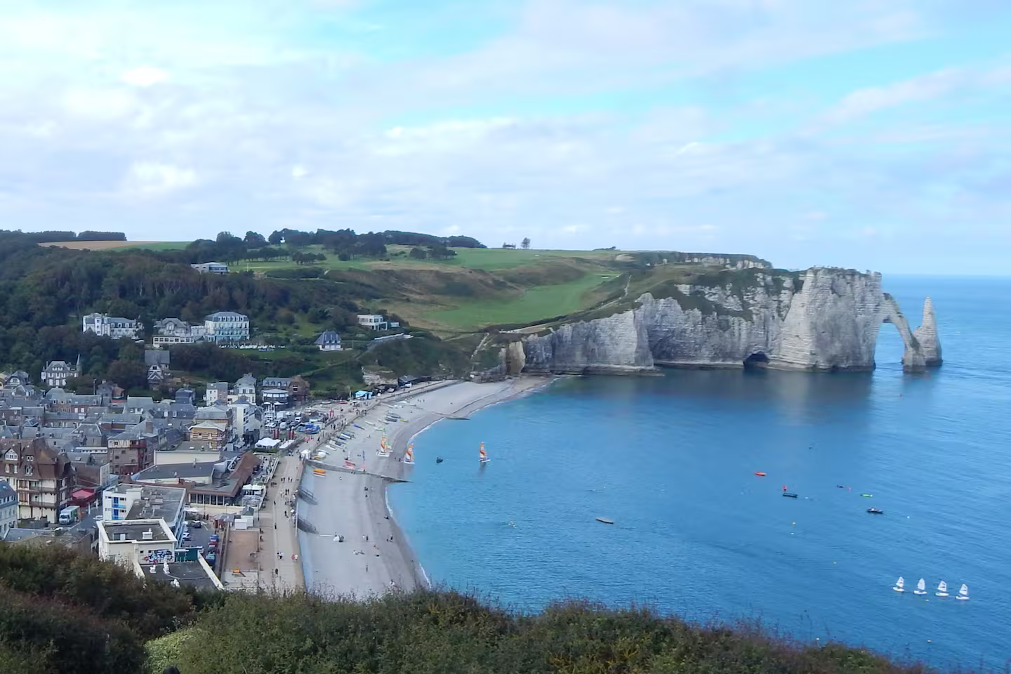 Une falaise surplombant un plan d'eau avec une ville en arrière-plan