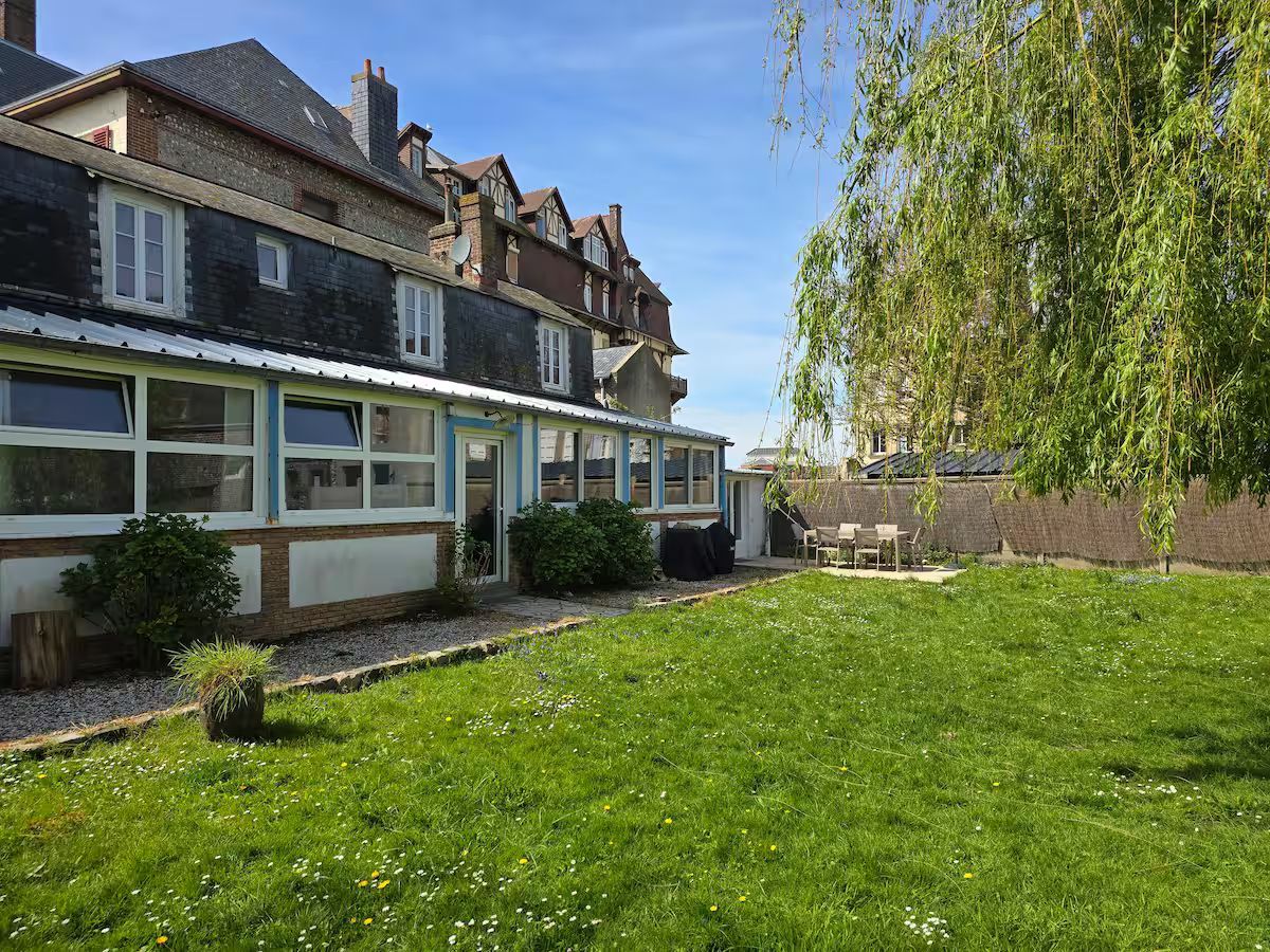 Une grande maison avec une grande pelouse devant elle.