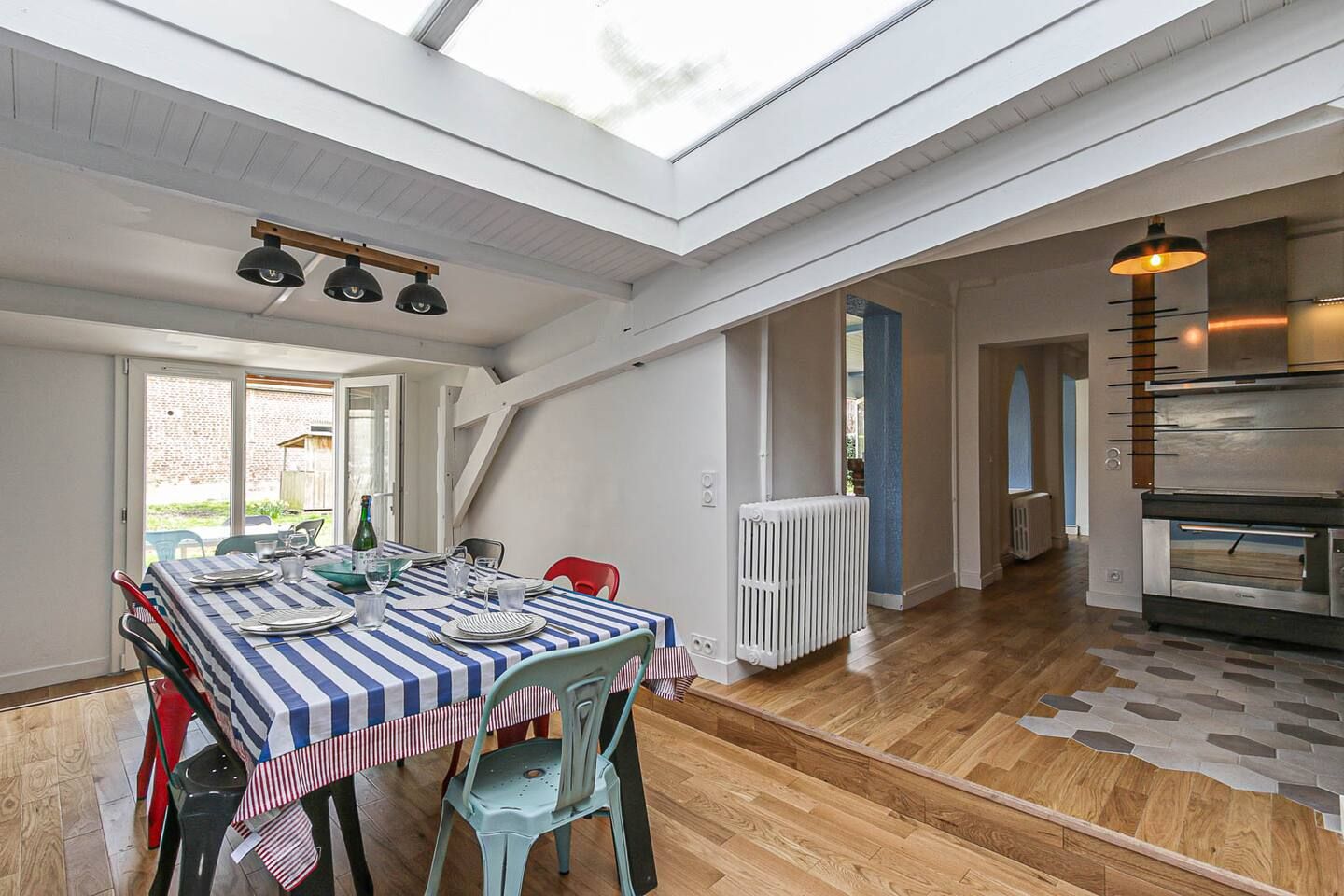Une salle à manger avec une table et des chaises et un puits de lumière.