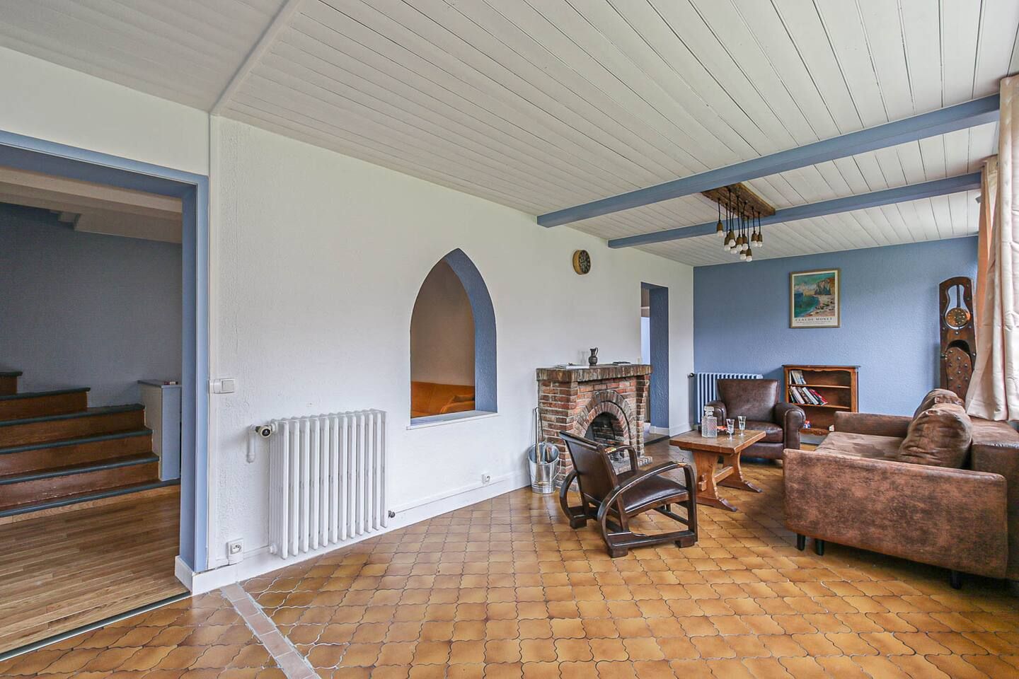 Un salon avec cheminée, canapé, chaise et table.