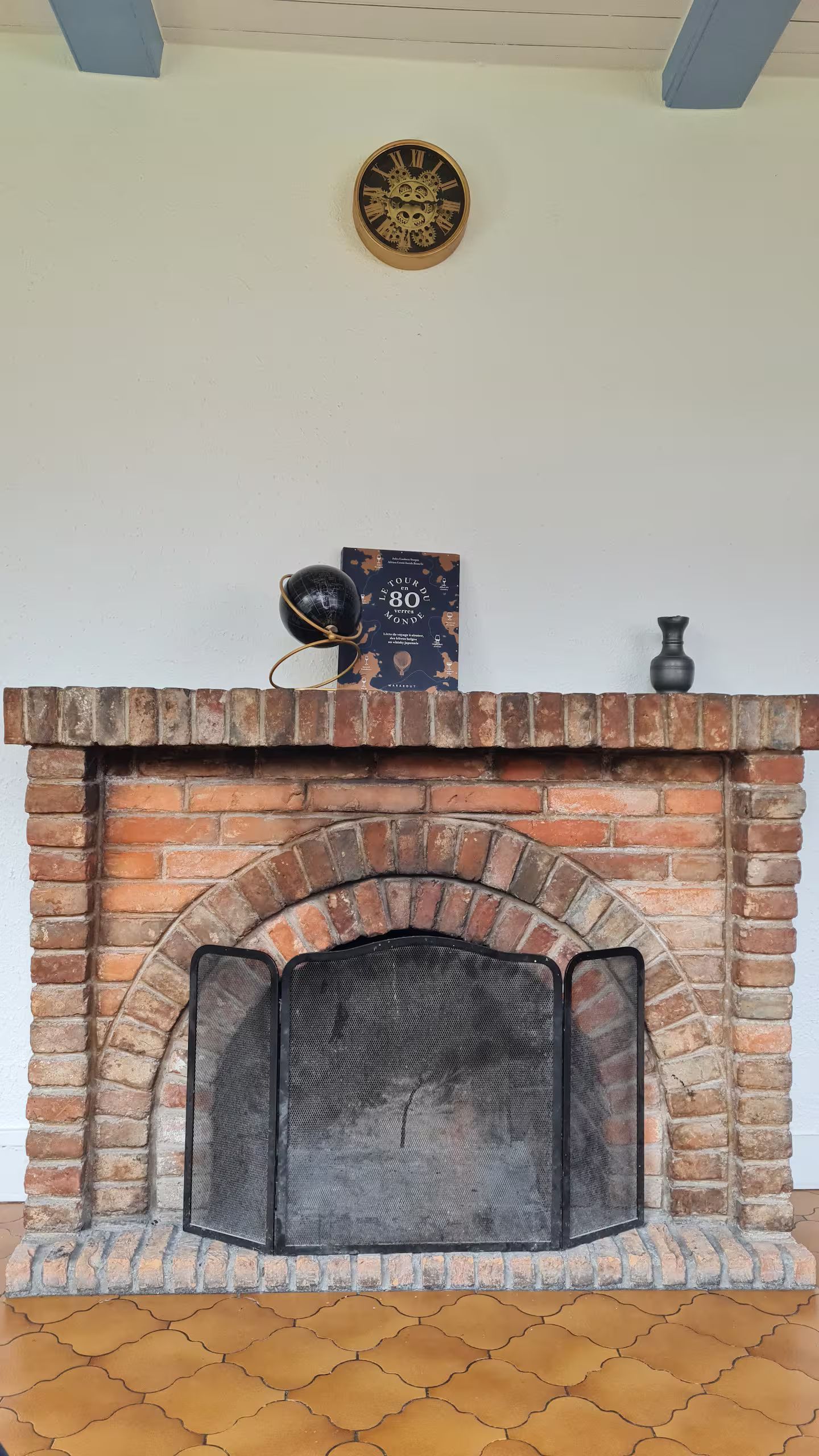 Une cheminée en briques avec une horloge sur le mur au-dessus.