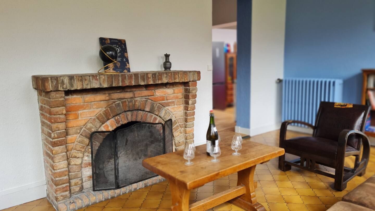 Un salon avec cheminée, table, chaise et canapé.