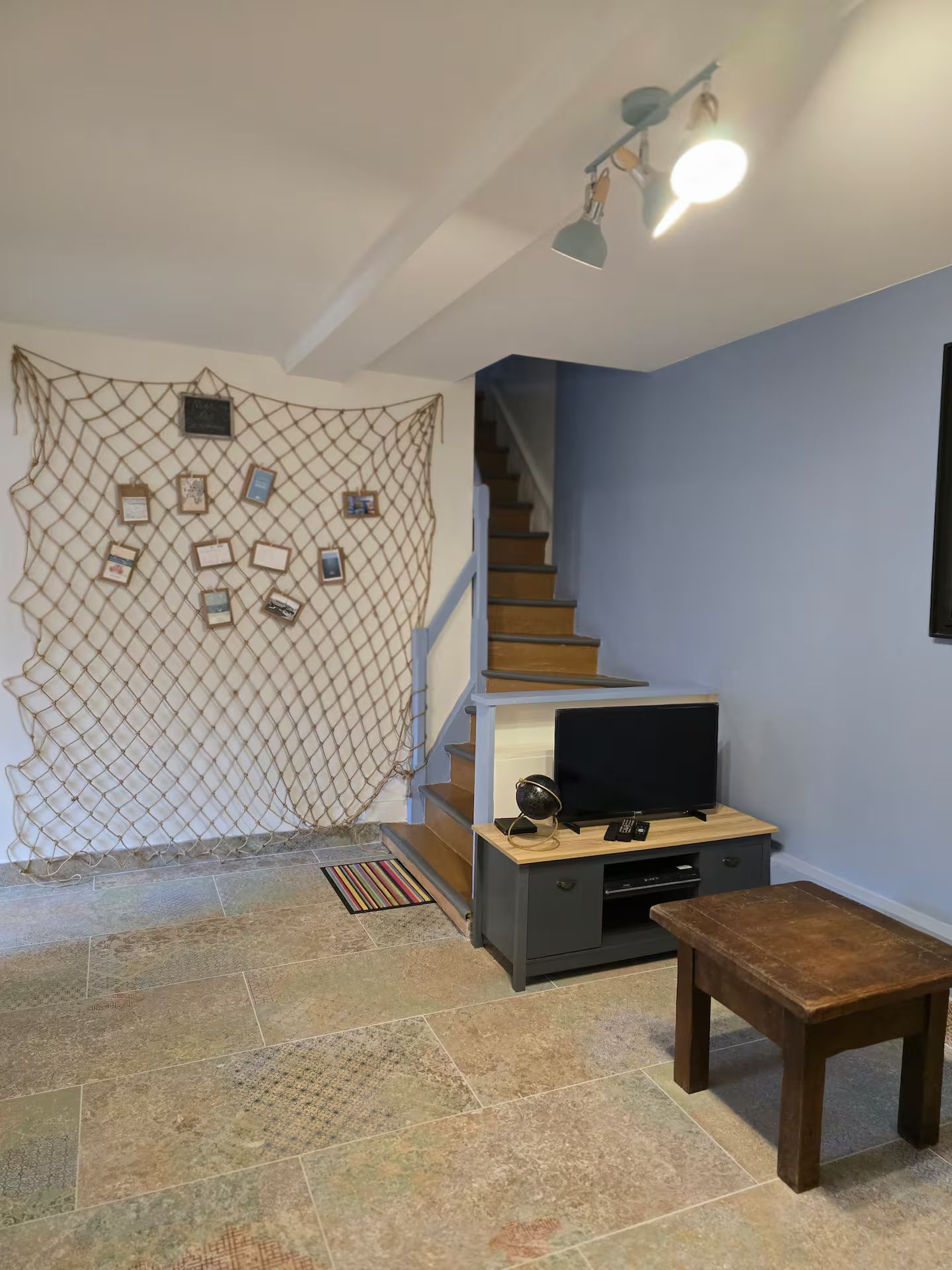 Un salon avec une télévision et des escaliers.