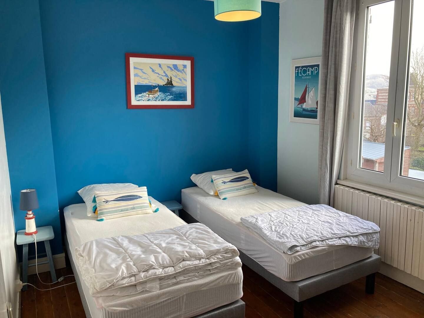 Une chambre avec deux lits jumeaux et une fenêtre.