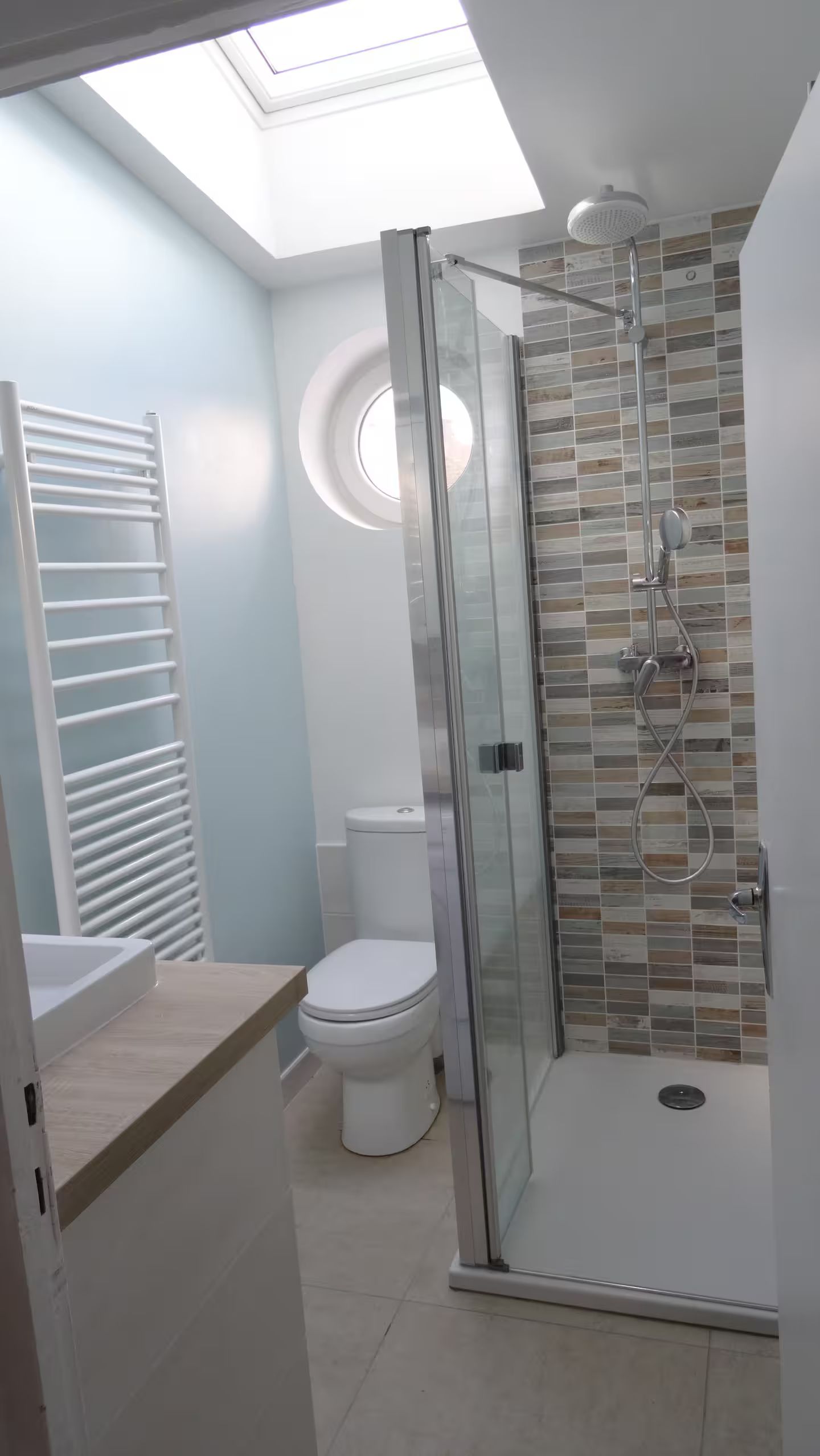 Une salle de bain avec WC, lavabo et douche.