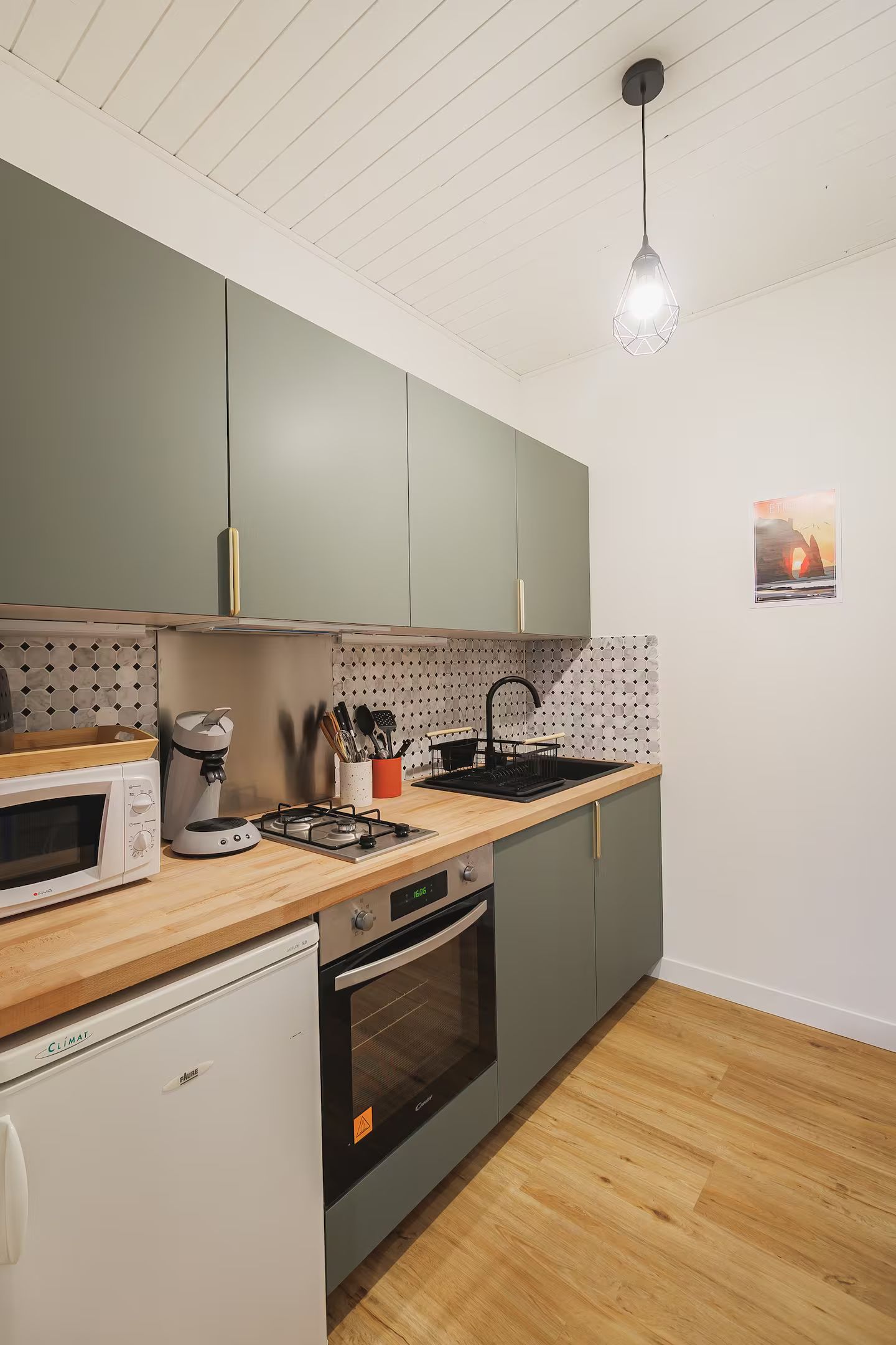 Une cuisine avec un évier, une cuisinière, un micro-ondes et un lave-vaisselle.