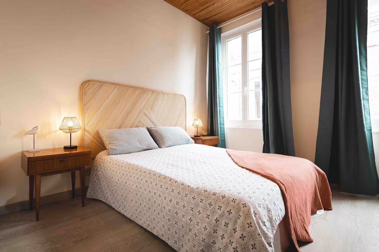 Une chambre avec un lit, une table de chevet et une fenêtre.