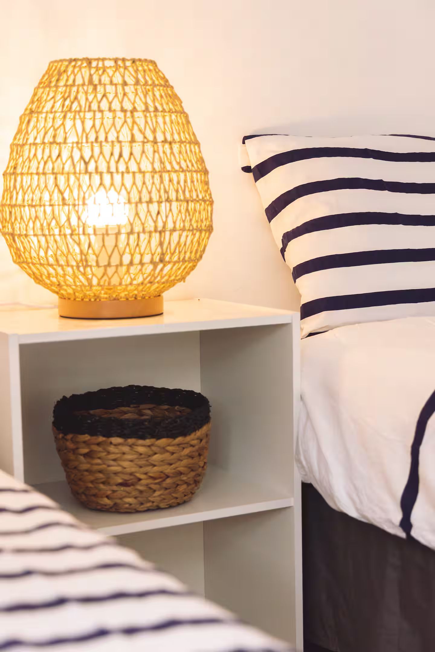 Une chambre avec deux lits et une lampe sur une table de chevet