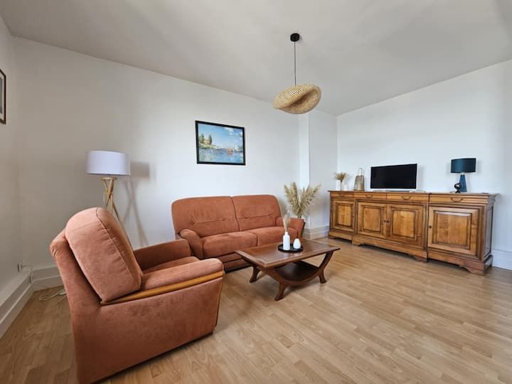Salon avec meubles orange, armoire en bois et parquet.