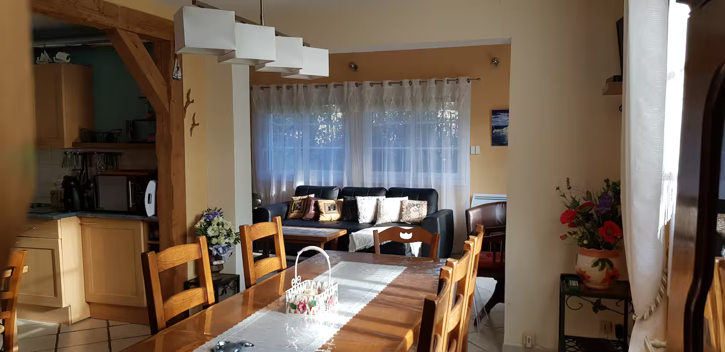 Une salle à manger avec une longue table en bois et des chaises.