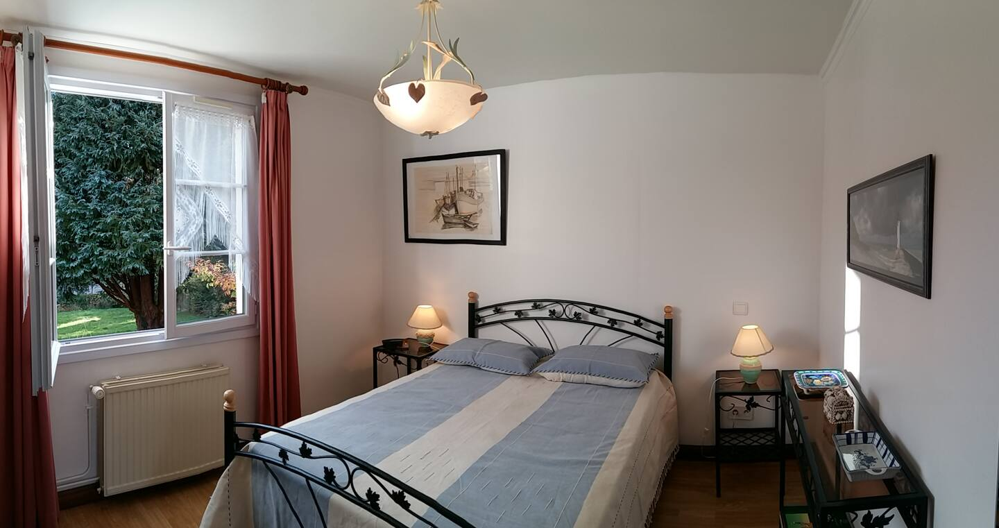 Une chambre avec un lit, deux tables de nuit et une fenêtre.