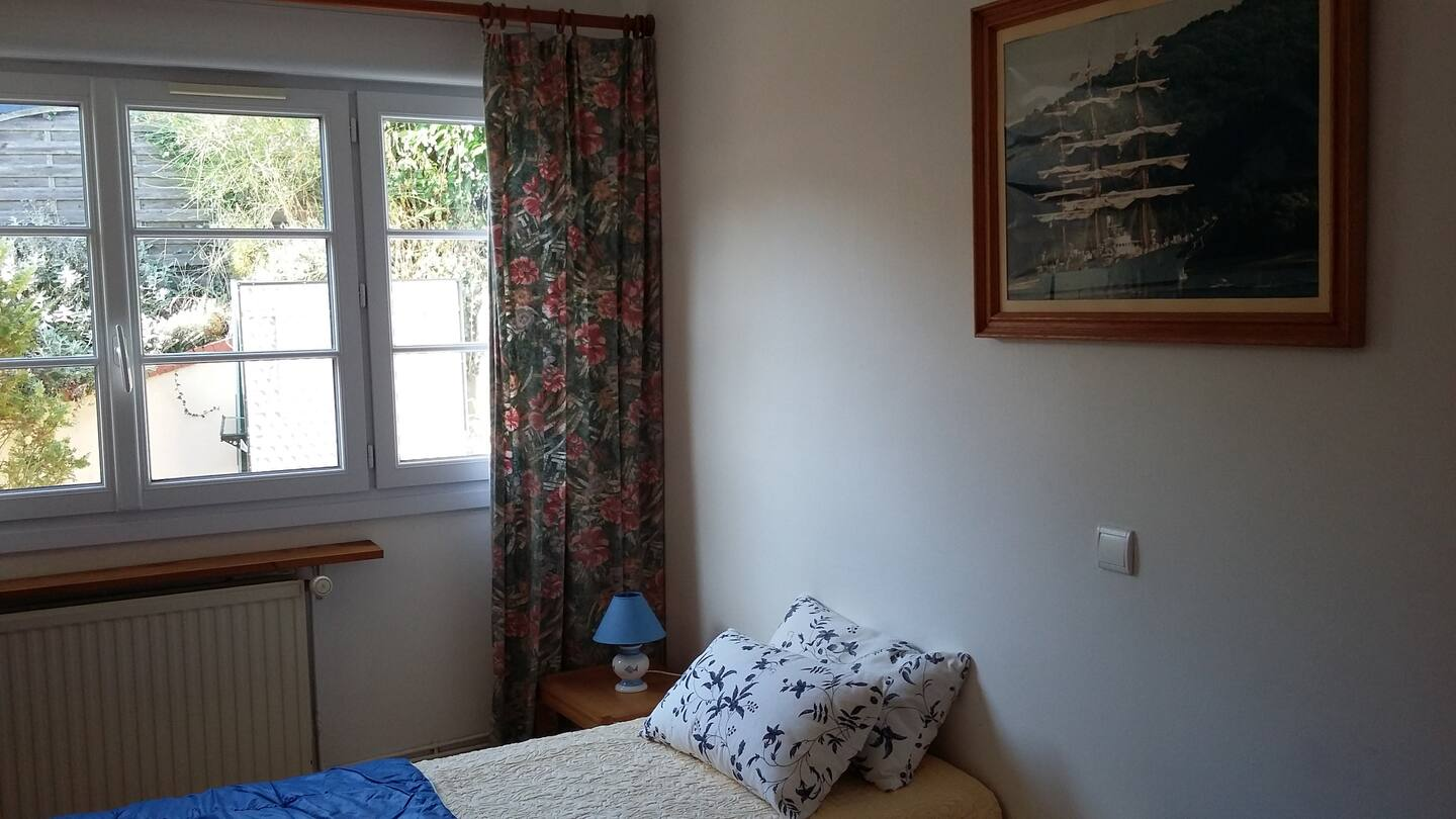 Une chambre avec un lit et un tableau au mur.