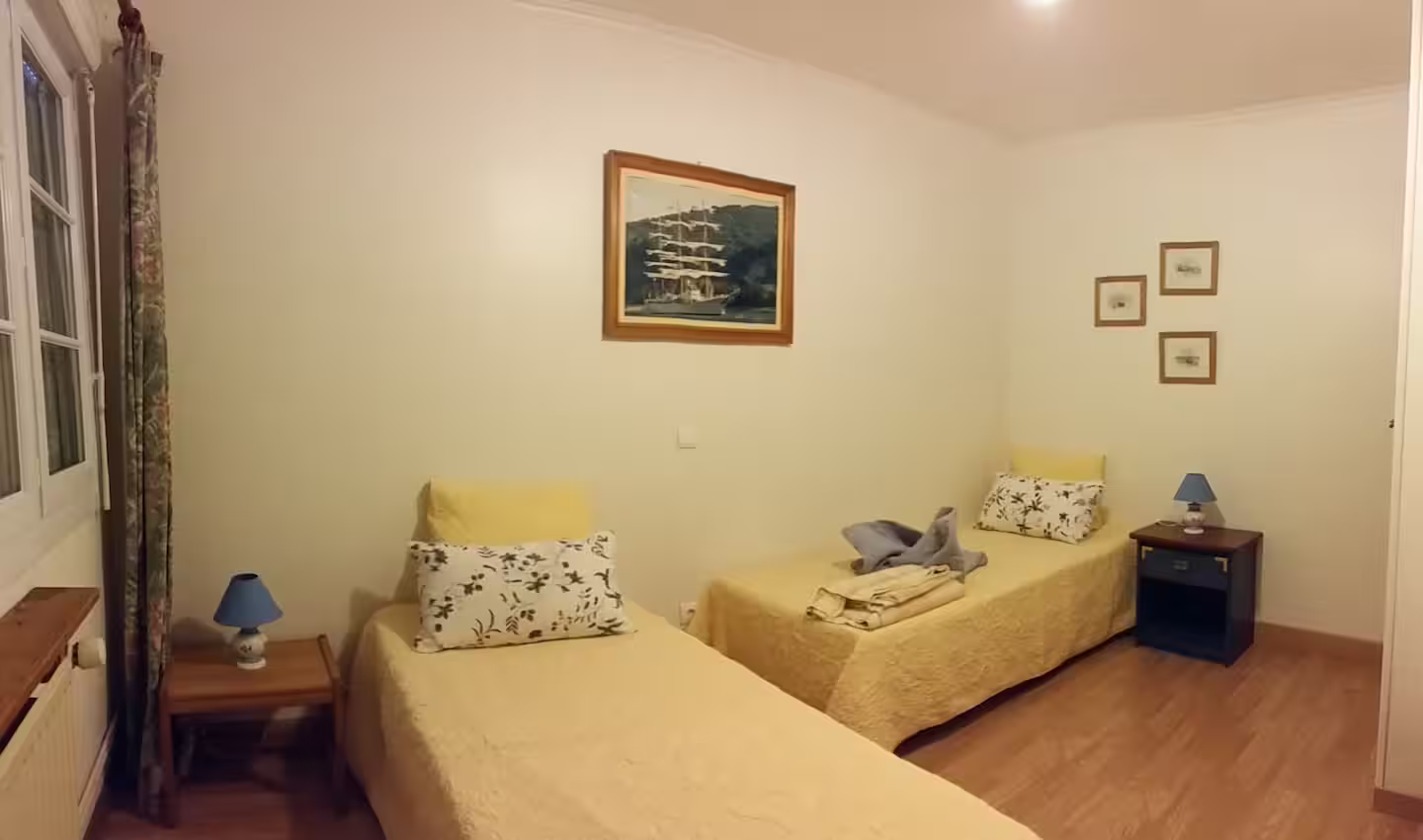 Une chambre avec deux lits et un tableau au mur