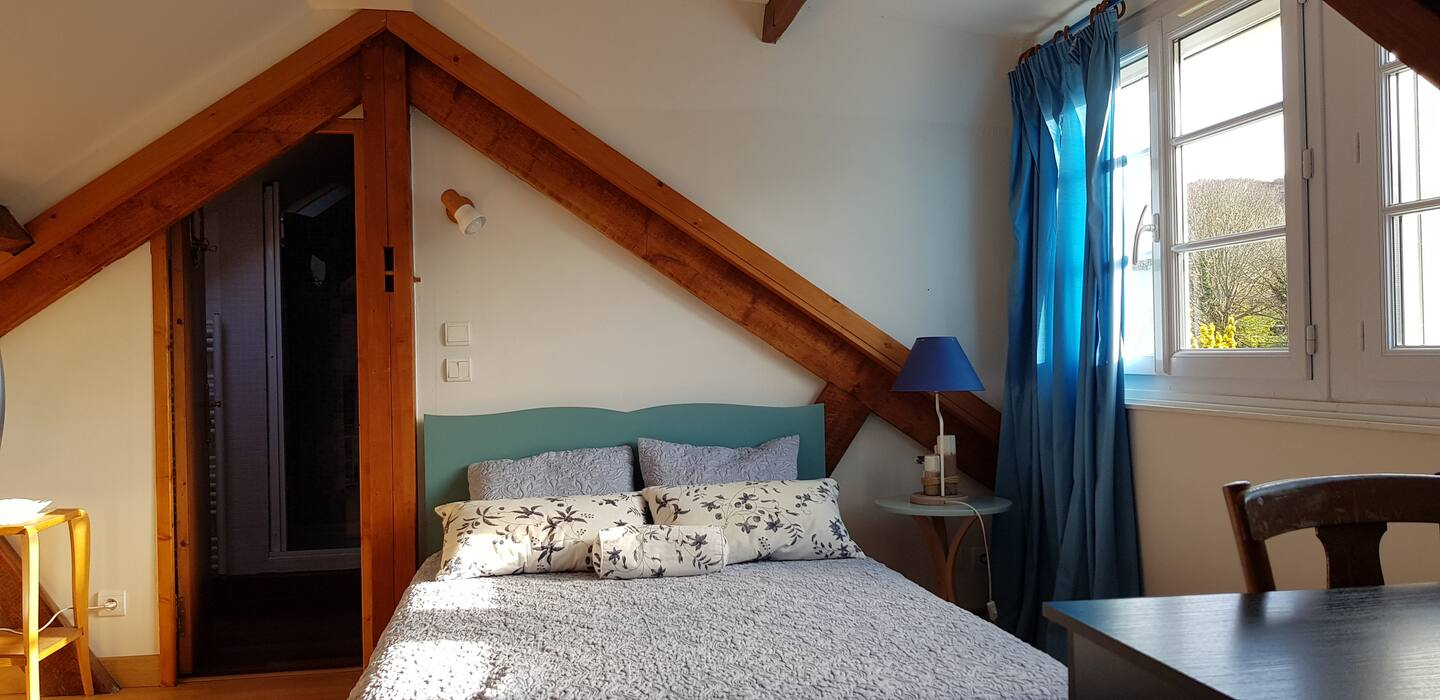Une chambre avec un lit, une table, des chaises et une fenêtre.
