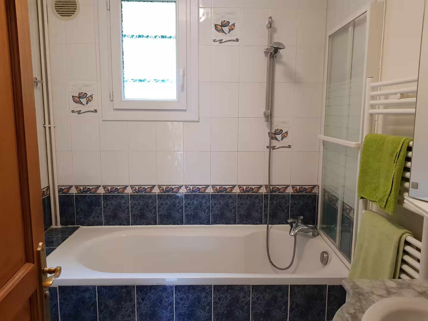 Une salle de bain avec baignoire, lavabo et douche.