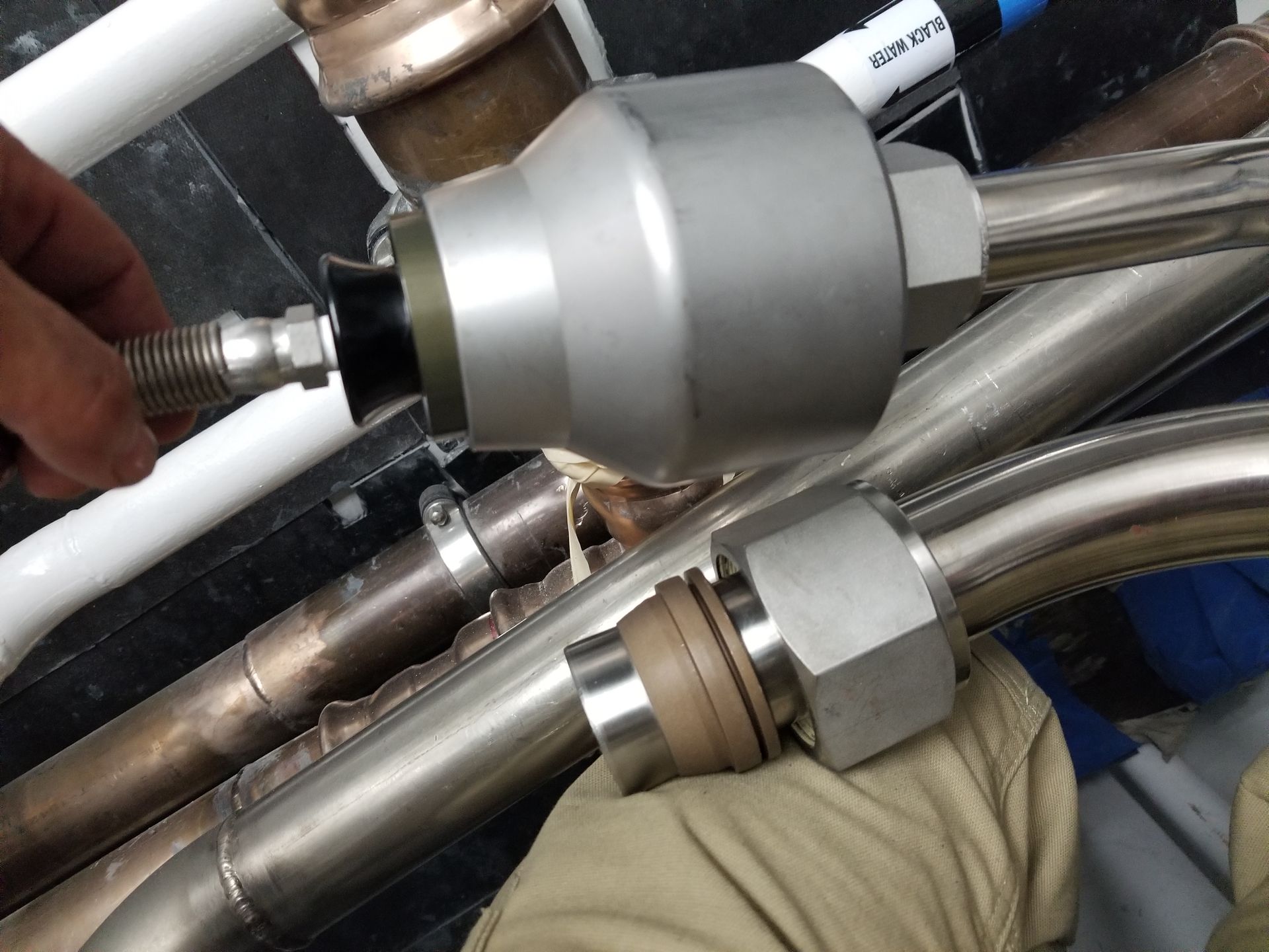 A person is holding a metal pipe with a hose attached to it
