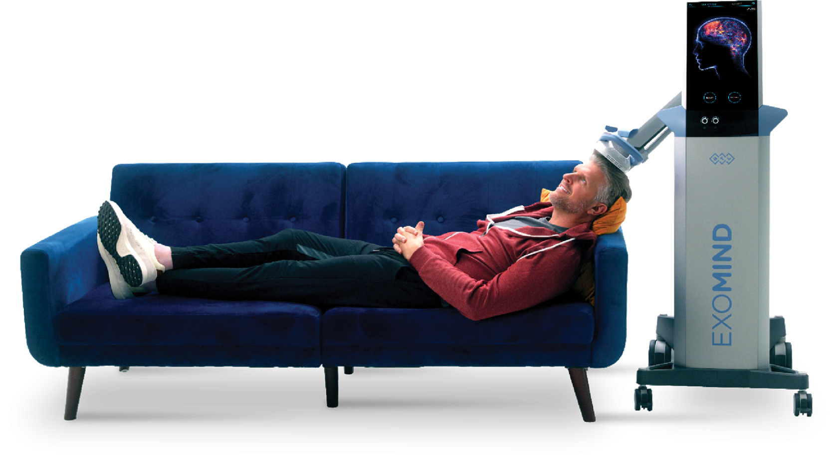 Man reclines on a blue couch, receiving a brain scan from an 