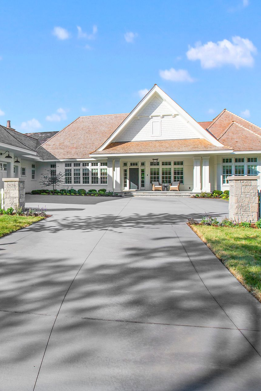 Blue-sided house with white garage door and concrete driveway on a sunny day. Blue-sided house with white garage door and concrete driveway on a sunny day.