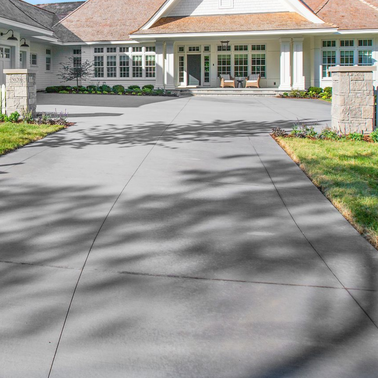 Blue-sided house with white garage door and concrete driveway on a sunny day. Blue-sided house with white garage door and concrete driveway on a sunny day.
