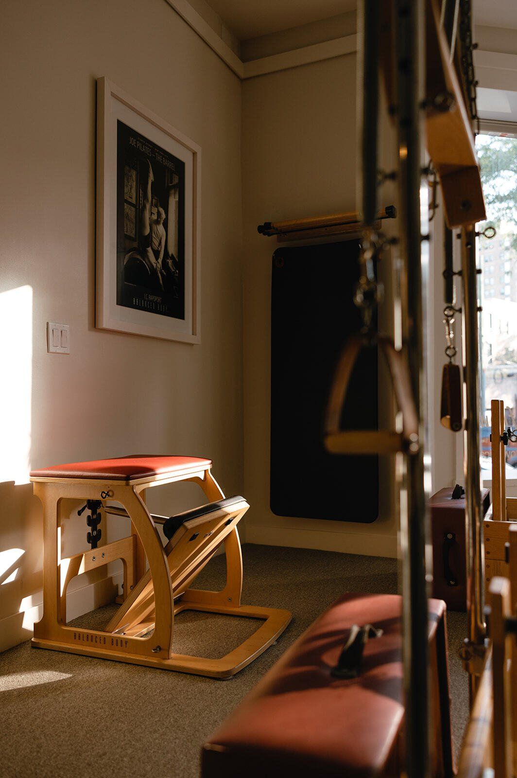 A room with a bench and a pilates chair in it.