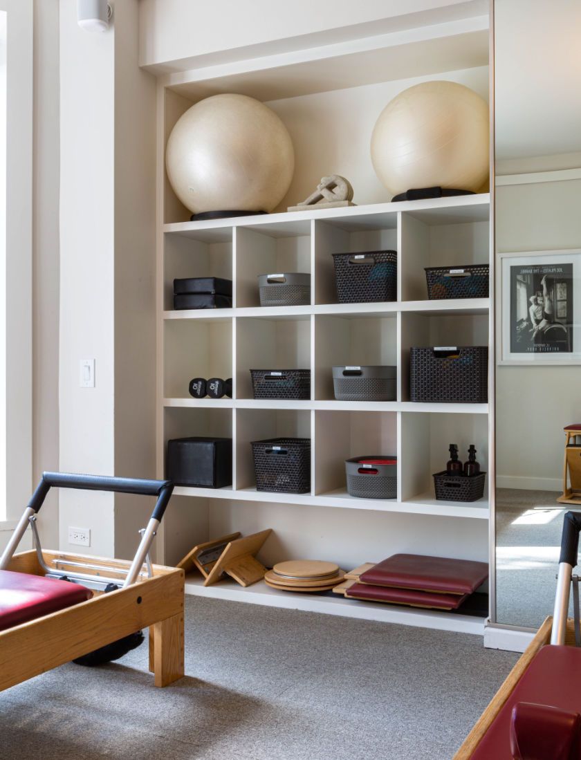 A room with shelves and a pilates reformer