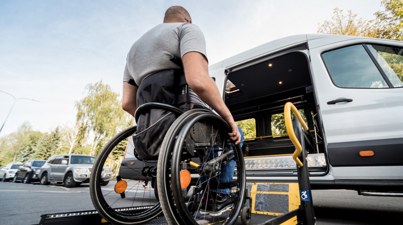 A man in a wheelchair is getting into a van.
