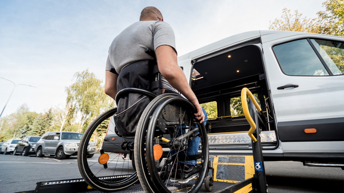 A man in a wheelchair is getting into a van.