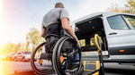 A man in a wheelchair is getting into a van.
