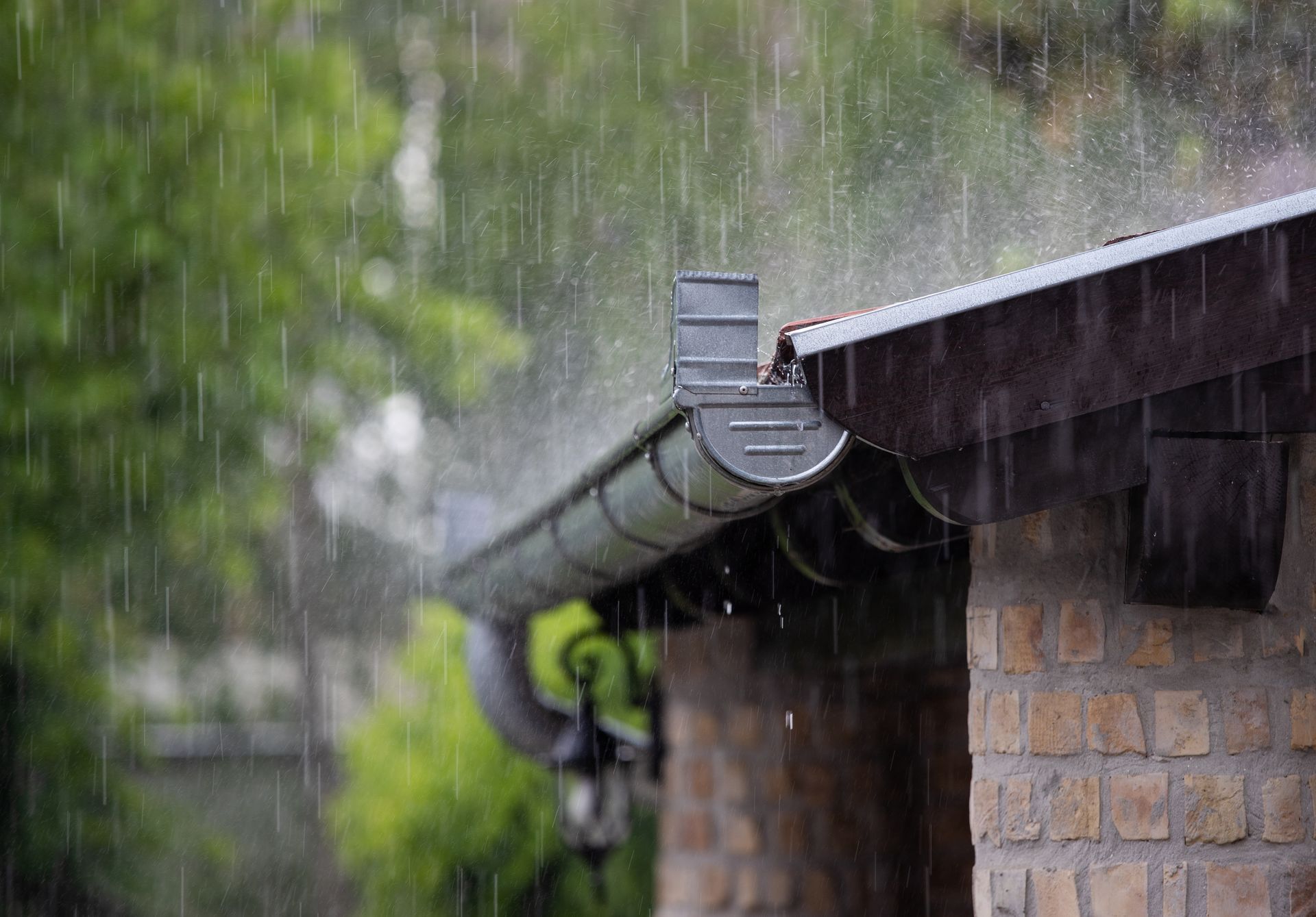 Rain falling on a building's roof and gutter.
