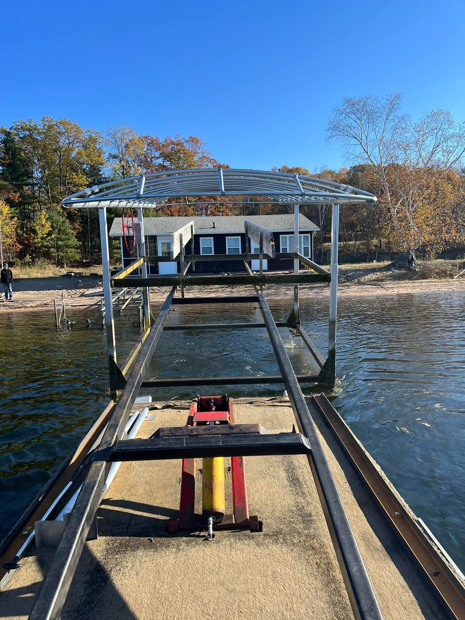 Dock ramp extending to a boat on a calm lake under a clear blue sky