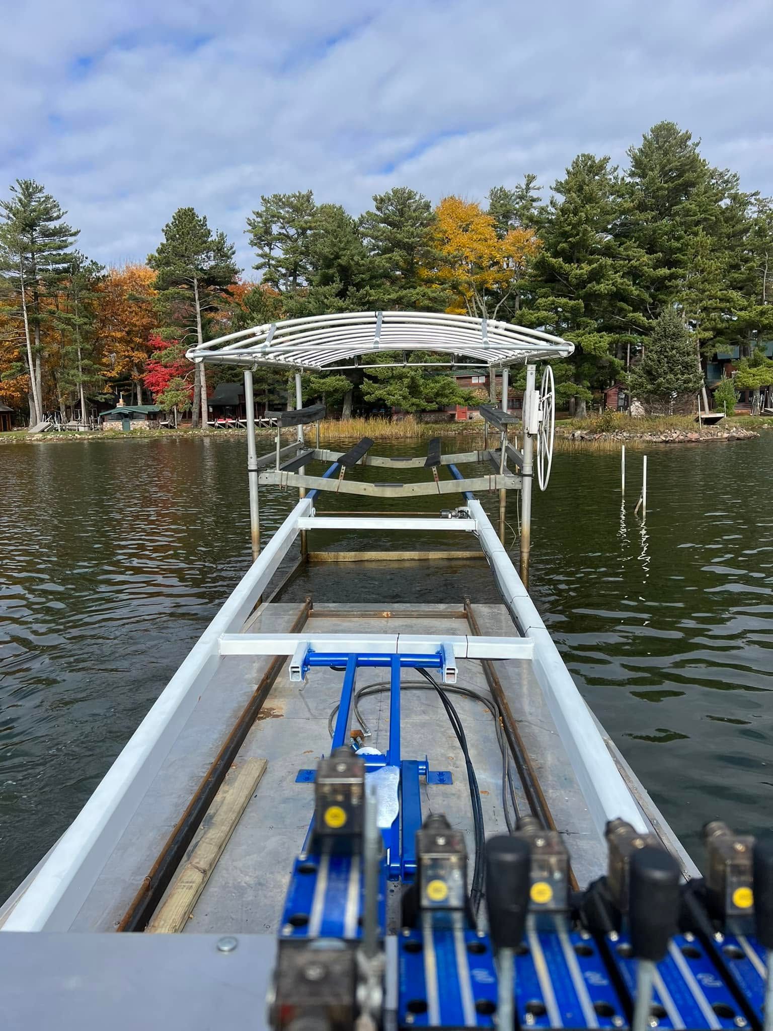View from a small boat toward a lakeside dock under autumn trees