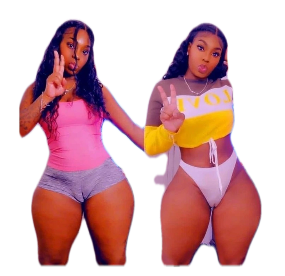 Two women standing next to each other with one giving a peace sign