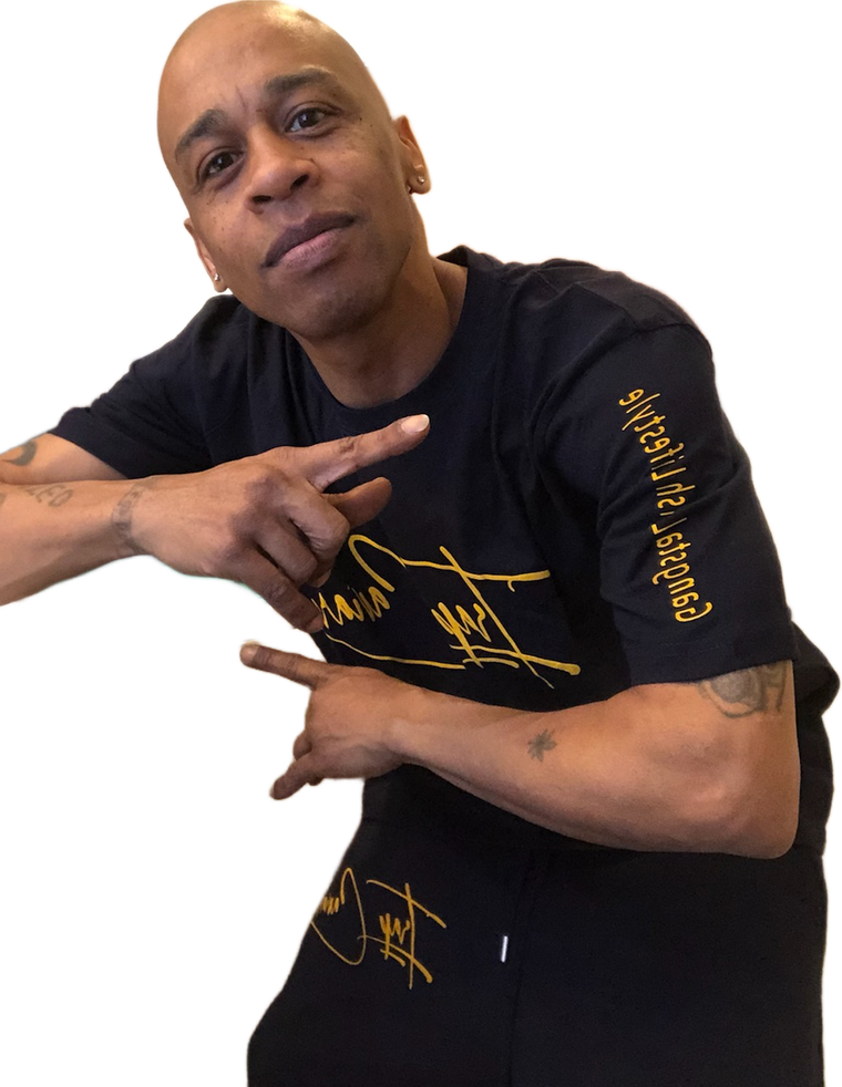 A bald man wearing a black t-shirt with a gold signature on the sleeve