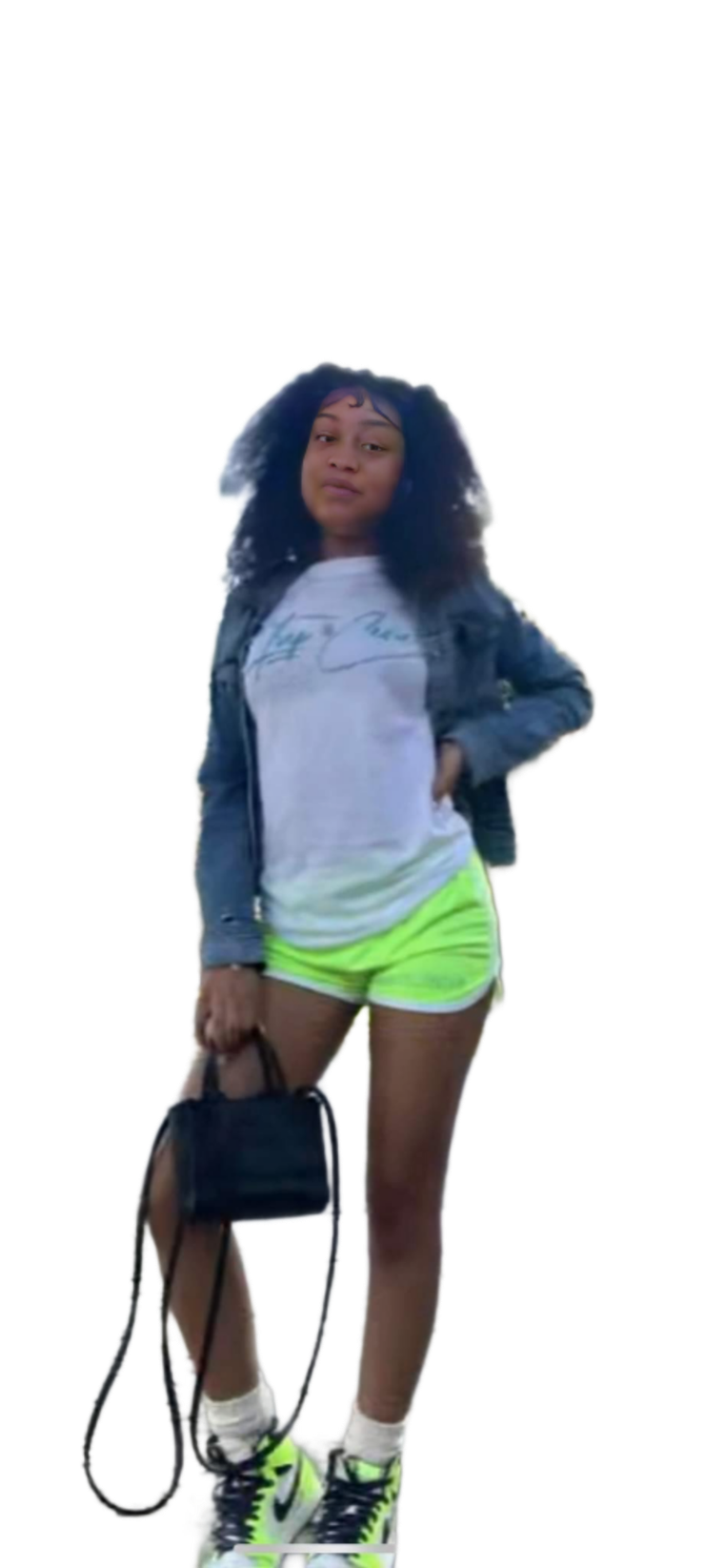 A woman in a white shirt and neon green shorts is holding a black purse.
