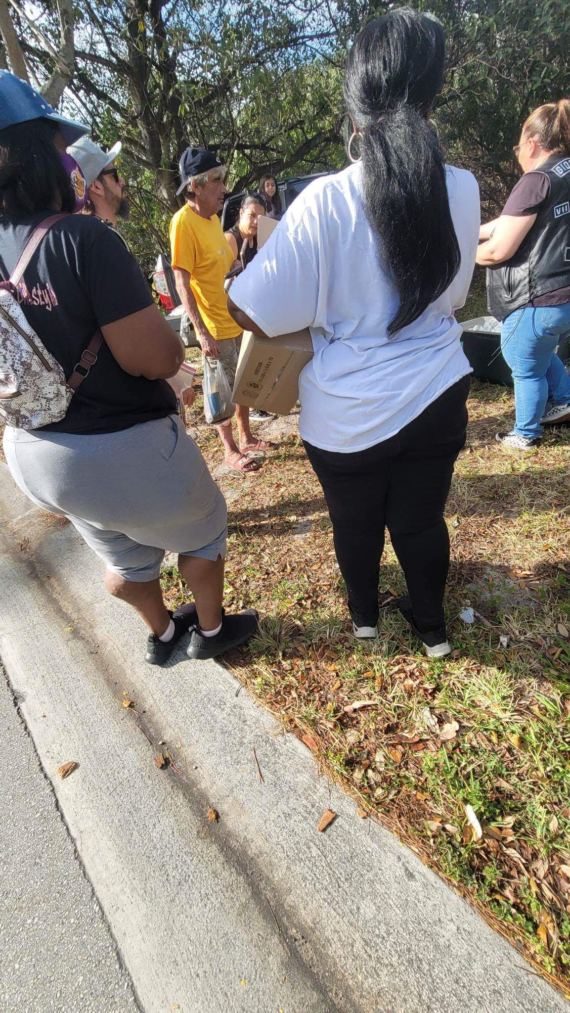 A group of people are standing on the side of the road.