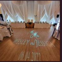 Wedding reception hall with projected monogram and names on a wooden dance floor