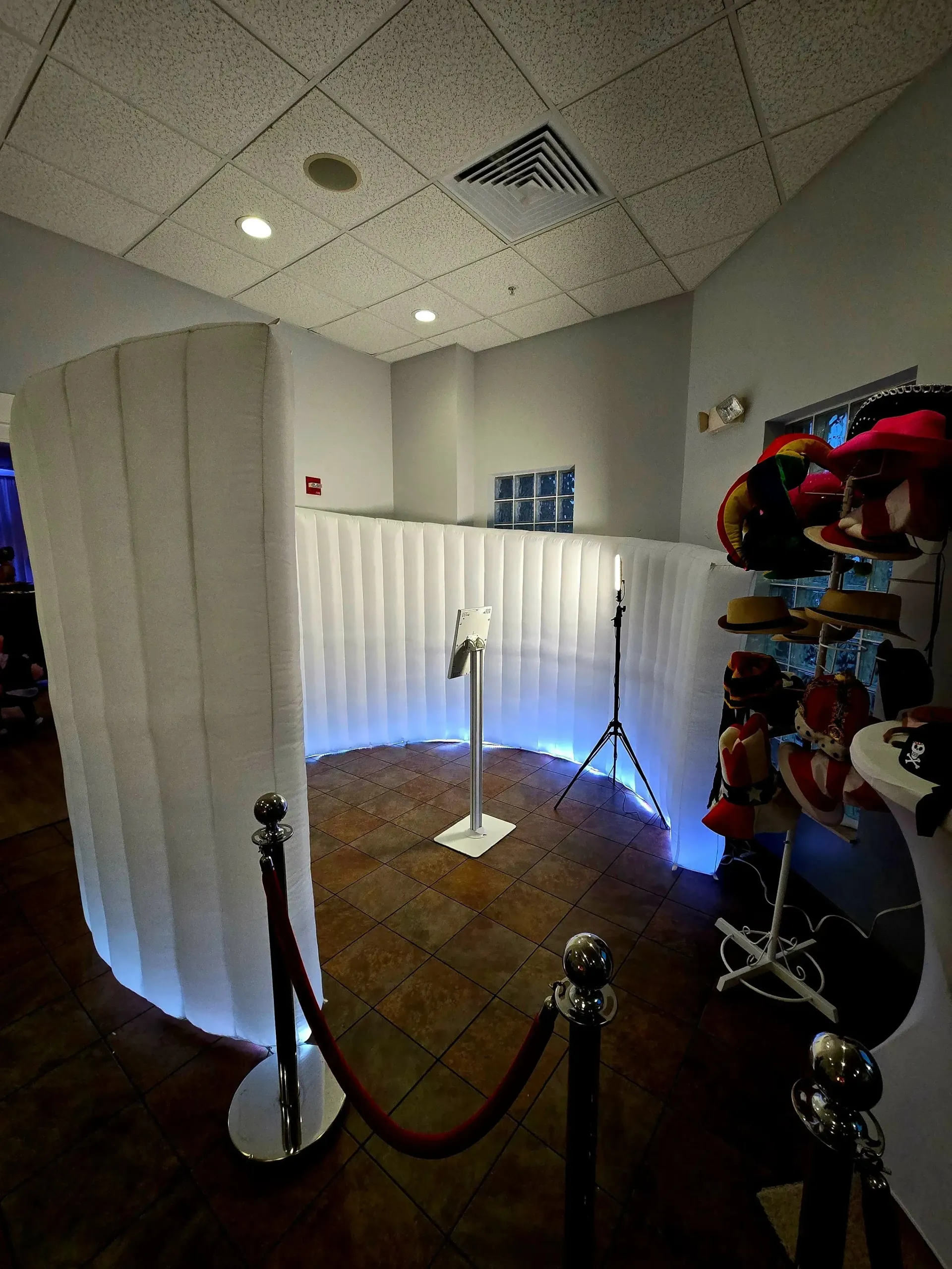 Curved exhibit space with white partition walls, stanchions, and a red-and-black display on the right
