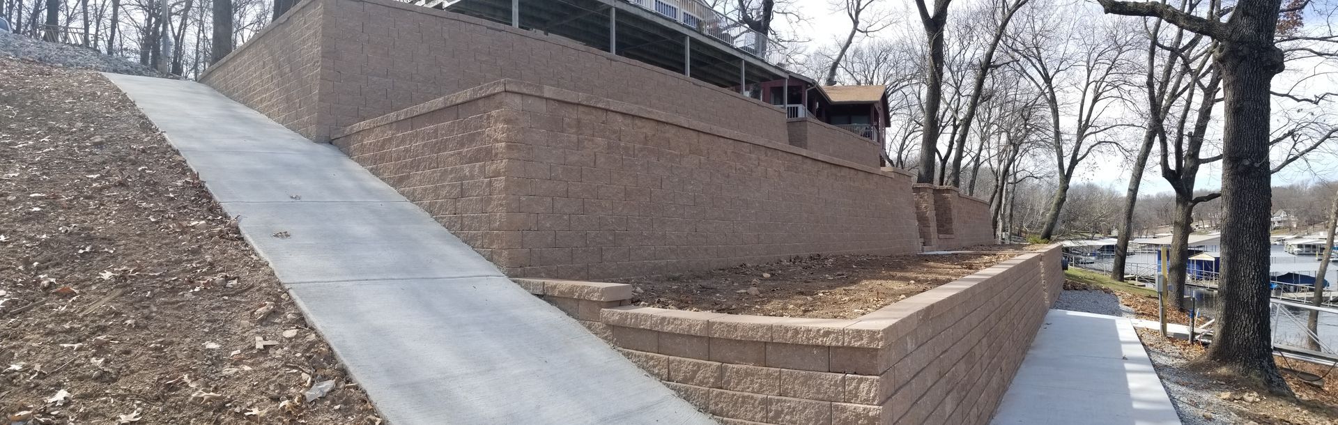A brick wall with a concrete walkway leading up to it.