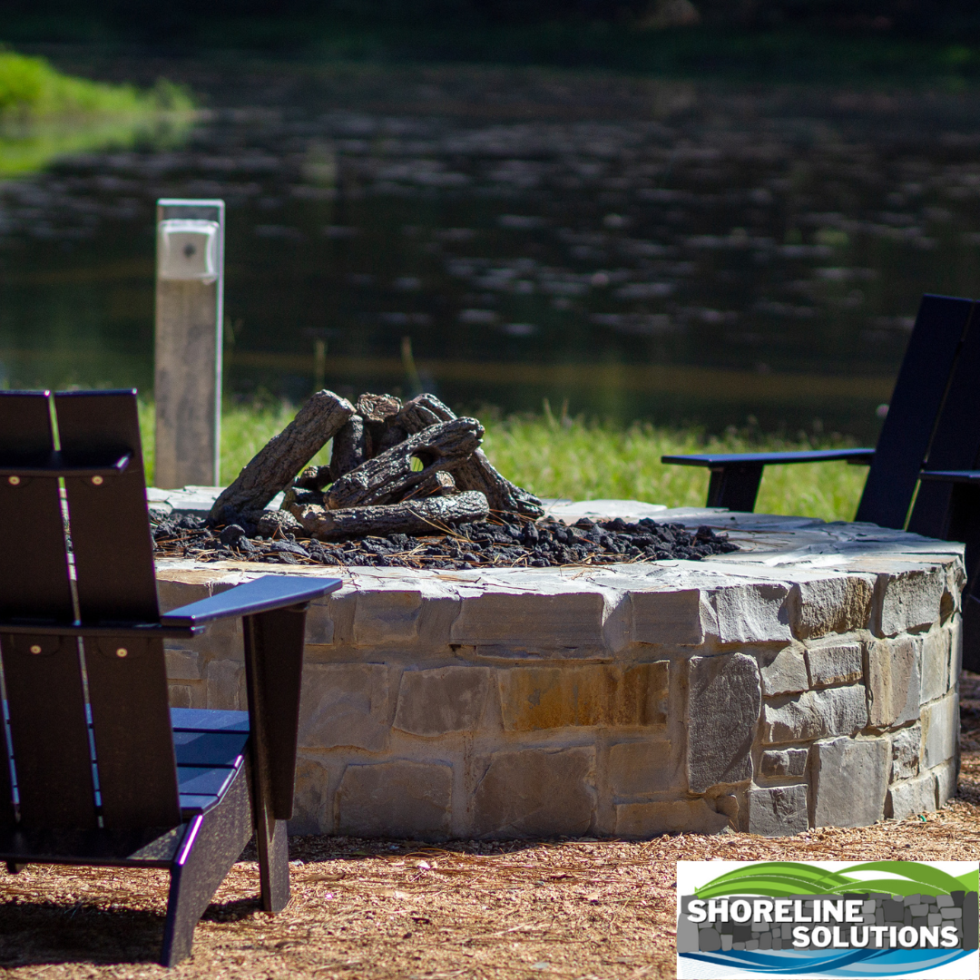 A fire pit with two chairs in front of it and a sign that says shoreline solutions