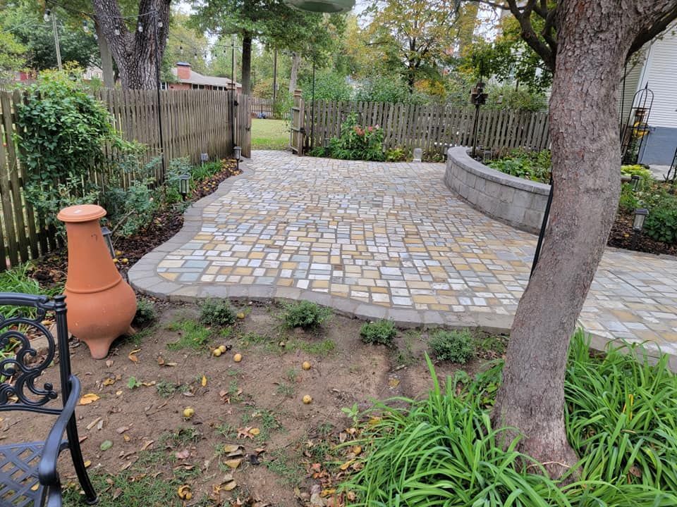 A cobblestone patio with retaining wall