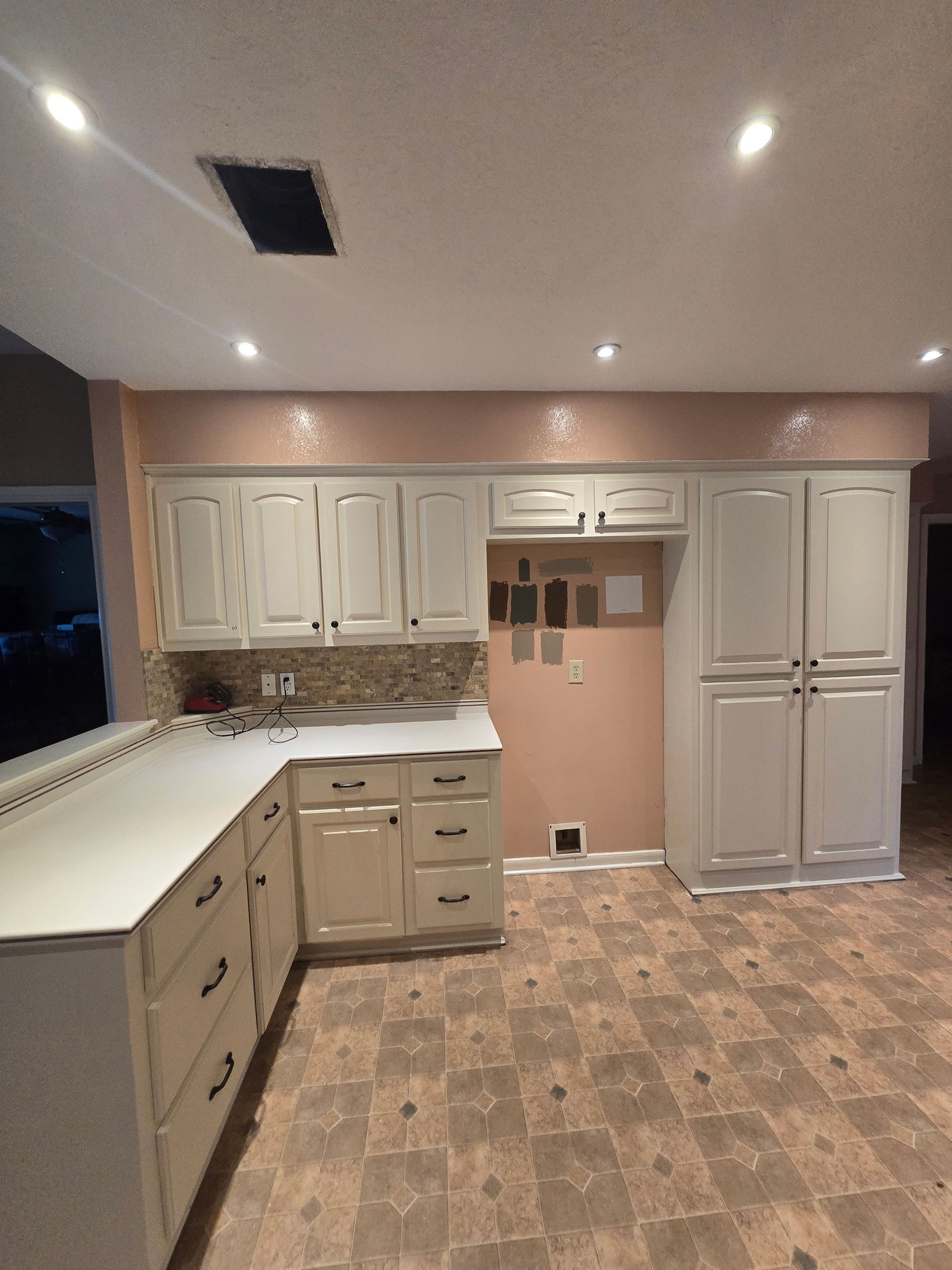 White built-in cabinet with glass doors and granite countertop in a small alcove