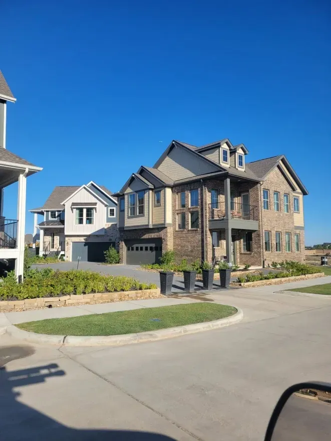 Residential street with modern suburban houses and a clear blue sky