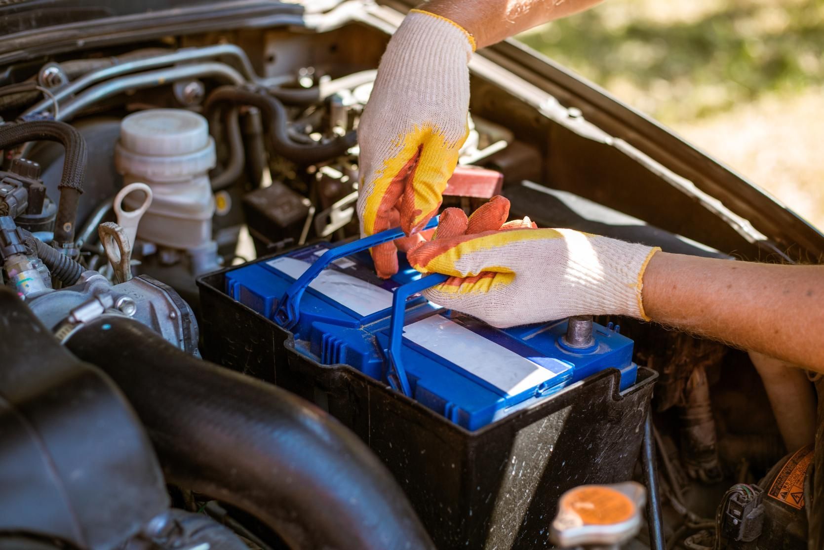 A person is plugging a battery into a car.