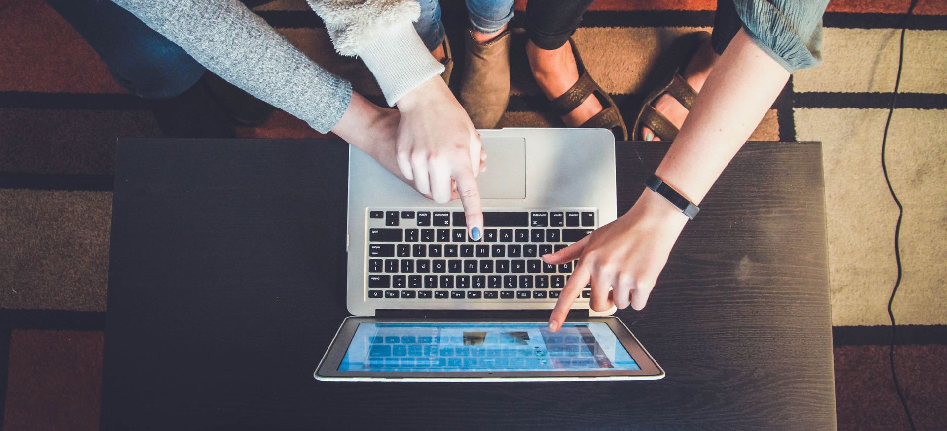 people pointing at a laptop