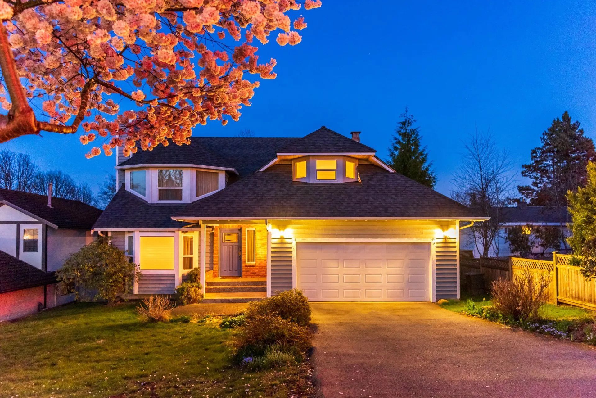 front of house, driveway garage, outdoor lighting.